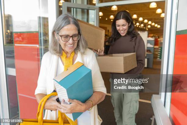 smiling hispanic women exiting shoe store in orlando florida - orlando florida family stock pictures, royalty-free photos & images