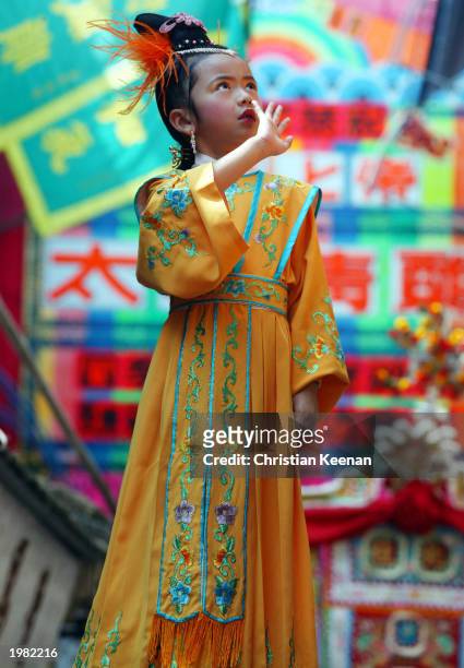 Child waves to spectators during the Bun festival on Cheung Chau Island May 8, 2003 in Hong Kong. The festival was first started to celebrate the end...