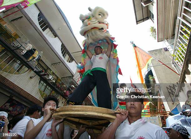 Lion dancers perform during the Bun festival on Cheung Chau Island May 8, 2003 in Hong Kong. The festival was first started to celebrate the end of a...