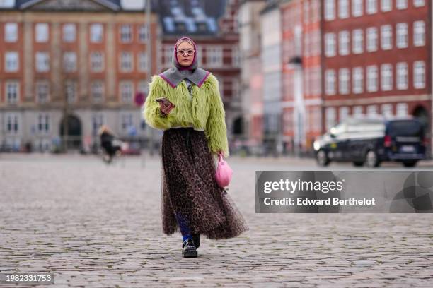 Guest wears a purple and gray ribbed wool balaclava / hood, a yellow / green fluffy oversized jacket , a flowing tulle leopard print pattern gathered...