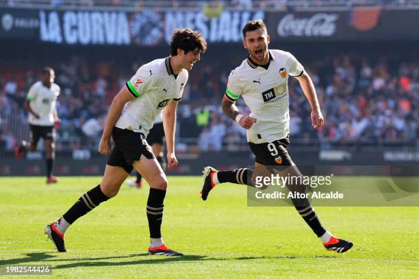 Hugo Duro of Valencia CF celebrates scoring his team's first goal with teammate Javi Guerra during the LaLiga EA Sports match between Valencia CF and...