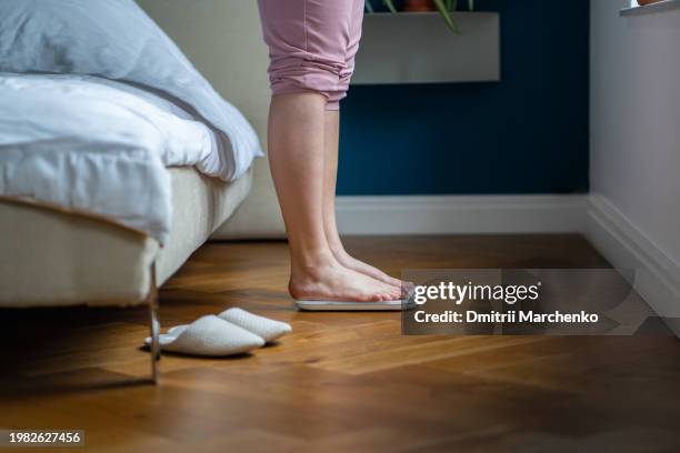 overweight female feet standing on electronic scales for excess weight control and reduction - kilogram stock pictures, royalty-free photos & images