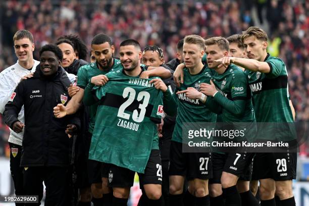 Deniz Undav of VfB Stuttgart celebrates scoring his team's first goal with teammates and displays the shirt of Dan-Axel Zagadou of VfB Stuttgart...