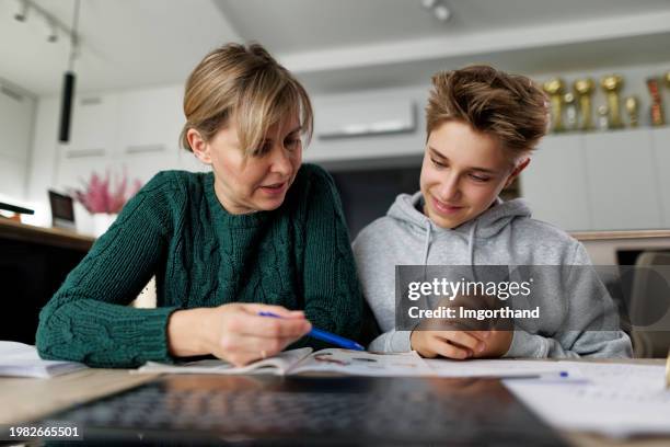 mother helping son with some homework - mother son real people serious stock pictures, royalty-free photos & images