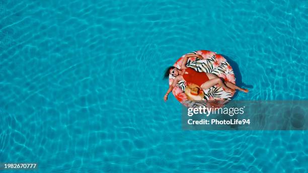 woman in red floating in the pool - red hat stock pictures, royalty-free photos & images