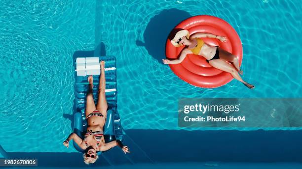 happy women friends having fun in the pool - floating on water stock pictures, royalty-free photos & images