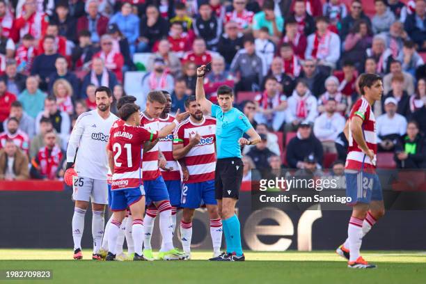 Referee Busquets Ferrer shosw a red card to Kamil Piatkowski of Granada CF during the LaLiga EA Sports match between Granada CF and UD Las Palmas at...