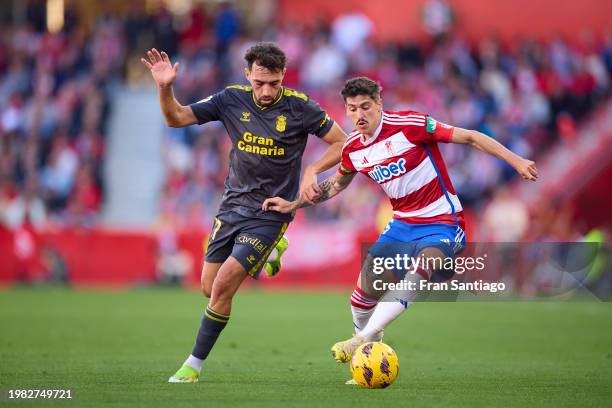 Carlos Neva of Granada CF competes for the ball with Munir El Haddadi of UD Las Palmas during the LaLiga EA Sports match between Granada CF and UD...