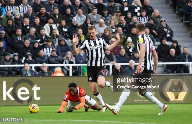 Chiedozie Ogbene of Luton Town clashes with Dan Burn of Newcastle United during the Premier League match between Newcastle United and Luton Town at...
