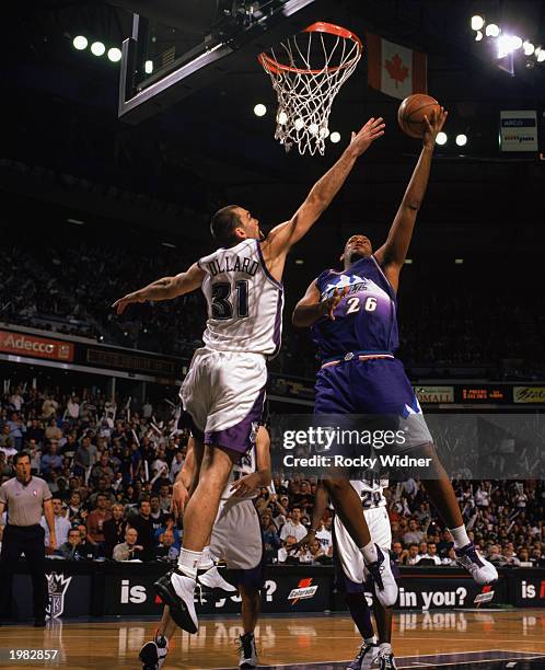 John Amaechi of the Utah Jazz goes to the hoop against Scot Pollard of the Sacramento Kings in Game 5 of the Western Conference Quarterfinals during...