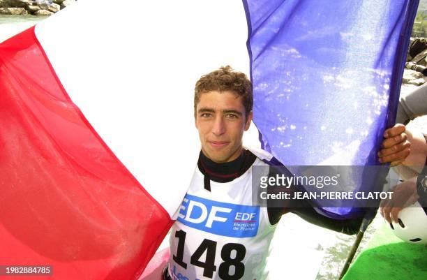 Le Français Fabien Lefèvre pose avec le drapeau tri-colore en signe de victoire, le 24 août 2002 sur le bassin de Bourg-Saint-Maurice, alors qu'il...