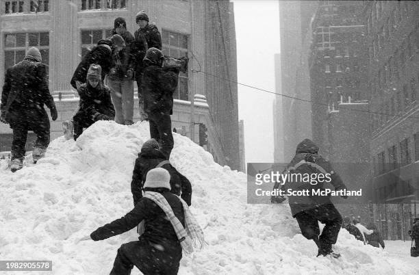 View of people climbing to the top of a snow mound on 5th Avenue during the President's Day blizzard, New York, New York, February 17, 2003.
