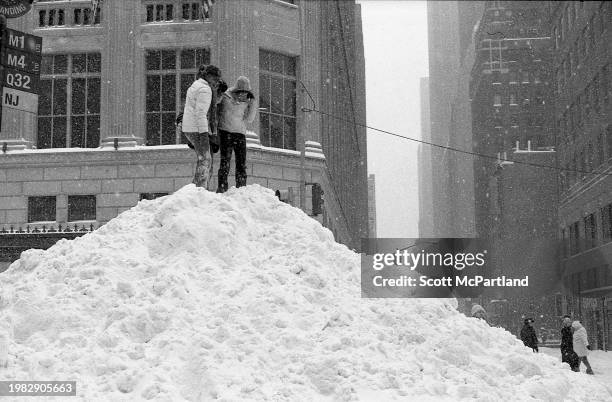 View of people standing on top of a snow mound on 5th Avenue during the President's Day blizzard, New York, New York, February 17, 2003.