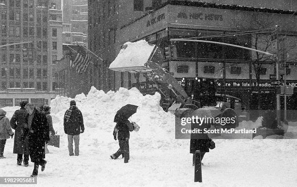 View of pedestrians, some holding umbrellas, outside Rockefeller Center during the President's Day blizzard, New York, New York, February 17, 2003....