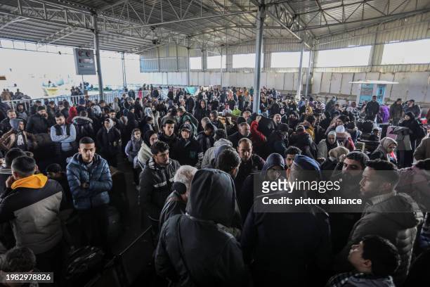 February 2024, Palestinian Territories, Rafah: Palestinians, holding foreign passports, prepare to cross to Egypt from the Gaza Strip through the...