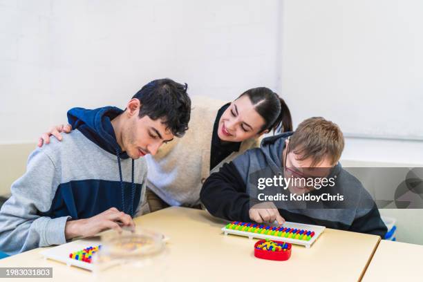 focused educational activity in classroom with special needs adults - special education stock pictures, royalty-free photos & images