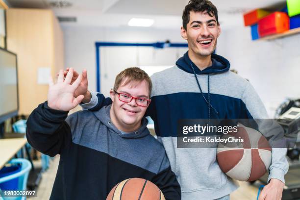 cheerful young men with disabilities playing basketball in gym - basketball all access stock pictures, royalty-free photos & images