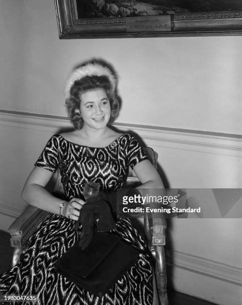 German aristocrat Cecilia Grafin von Weikersheim, wearing a short-sleeve patterned dress, with black evening gloves, and a hat with white fur trim, a...