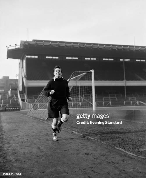 British footballer Vic Groves, Arsenal midfielder, running behind a goal during training at Highbury Stadium in London, England, 18th January 1956.