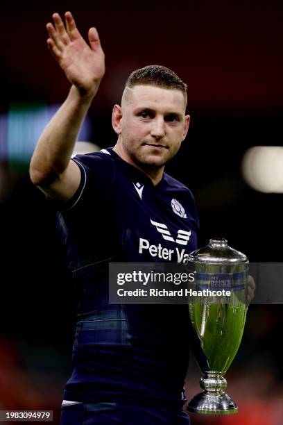 Finn Russell of Scotland gestures a wave as he holds the Doddie Weir Cup trophy following the teams victory in the Guinness Six Nations 2024 match...