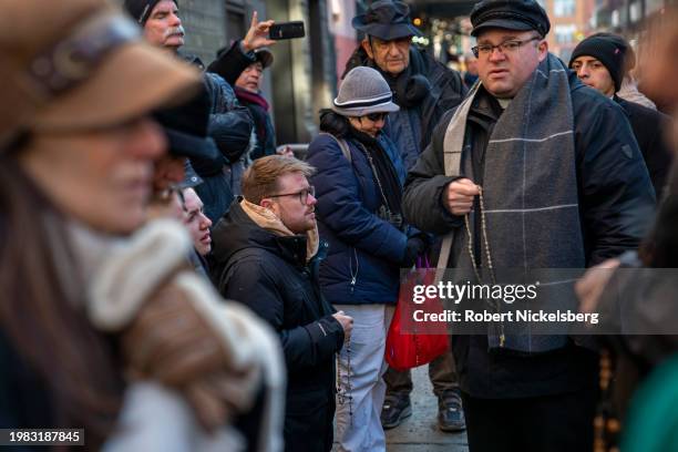 Roman Catholic priest holding rosary beads, right, recites a prayer with anti-abortion activists near the Planned Parenthood clinic where they are...