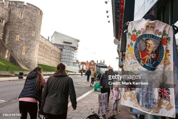 Souvenir of King Charles III's Coronation hangs outside a gift shop opposite Windsor Castle on 6th February 2024 in Windsor, United Kingdom. It was...