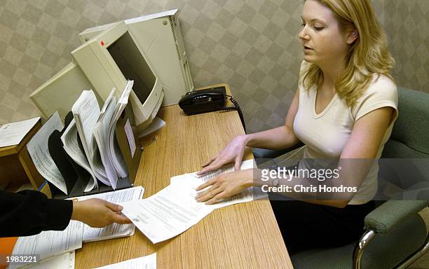 Worker at the Department of Labor recieves a form from a recipient of unemployment benefits May 8, 2003 in New York City. The nation's jobless rate...