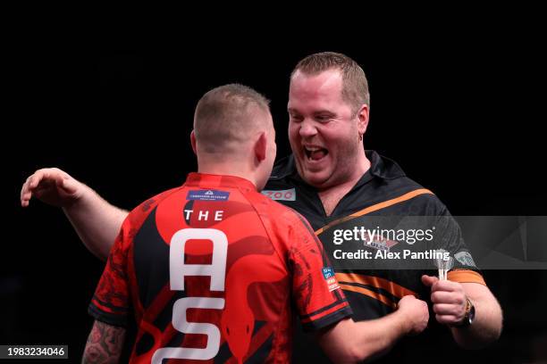 Dirk van Duijvenbode congratulates Nathan Aspinall on victory after their match at Marshall Arena on February 03, 2024 in Milton Keynes, England.