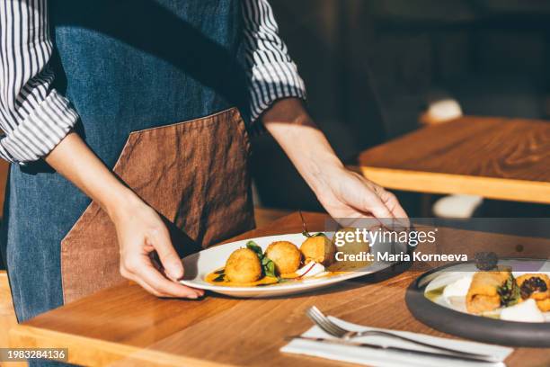 waitress serving food in a restaurant. - carrying table stock pictures, royalty-free photos & images