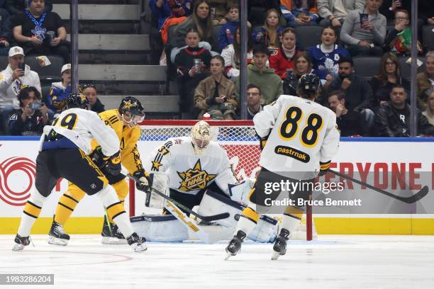 Connor Hellebuyck of the Winnipeg Jets makes a save against Sidney Crosby of the Pittsburgh Penguins during the game between Team Mackinnon and Team...