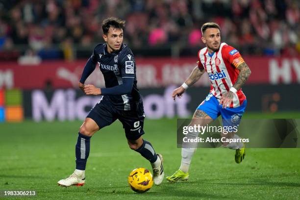 Martin Zubimendi of Real Sociedad controls the ball whilst under pressure from Aleix Garcia of Girona FC during the LaLiga EA Sports match between...