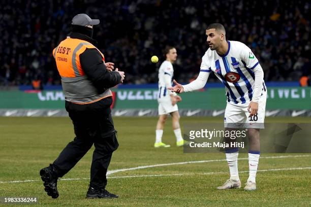 Aymen Barkok of Hertha Berlin throws a tennis ball that was thrown on the pitch to a steward during the Second Bundesliga match between Hertha BSC...
