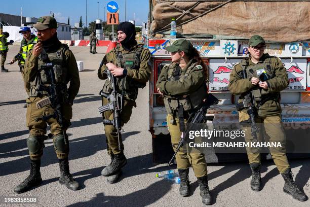 Israeli army soldiers stand by one of the Egyptian trucks bringing in humanitarian aid supplies to the Gaza Strip, on the Israeli side of the Kerem...