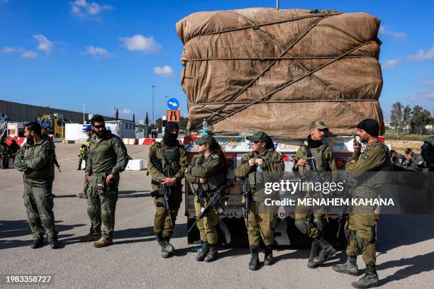 Israeli army soldiers stand by one of the Egyptian trucks bringing in humanitarian aid supplies to the Gaza Strip, on the Israeli side of the Kerem...