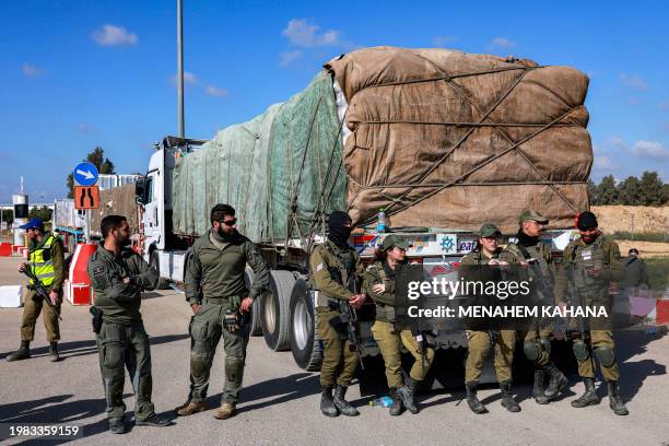 Israeli army soldiers stand by one of the Egyptian trucks bringing in humanitarian aid supplies to the Gaza Strip, on the Israeli side of the Kerem...