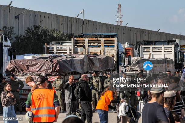 Israeli security forces stand by Egyptian trucks bringing in humanitarian aid supplies to the Gaza Strip, on the Israeli side of the Kerem Shalom...