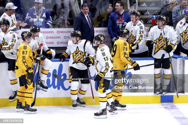 Sidney Crosby of the Pittsburgh Penguins and Nathan MacKinnon of the Colorado Avalanche shake hands with Nick Suzuki of the Montreal Canadiens, Sam...