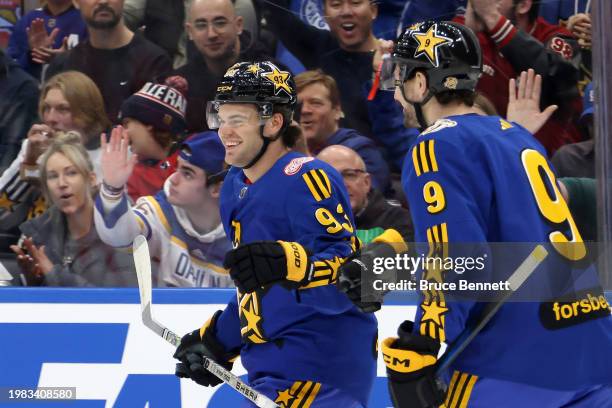 Alex DeBrincat of the Detroit Red Wings celebrates his goal with Filip Forsberg of the Nashville Predators during the game between Team Matthews and...