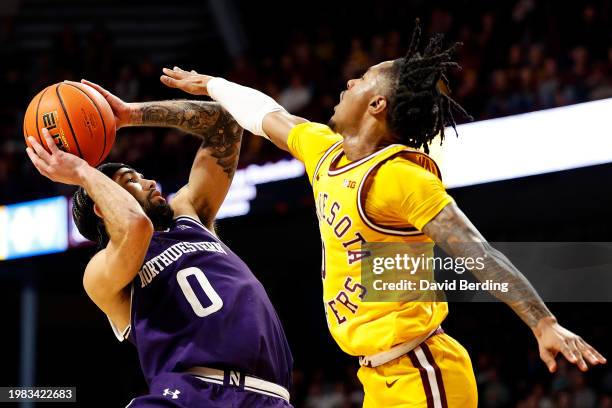 Boo Buie of the Northwestern Wildcats goes up for a shot against Elijah Hawkins of the Minnesota Golden Gophers in the second half at Williams Arena...