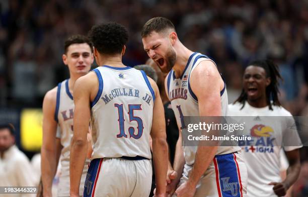 Hunter Dickinson of the Kansas Jayhawks celebrates with Kevin McCullar Jr. #15 after after McCullar Jr. Scored and drew a foul during the first half...