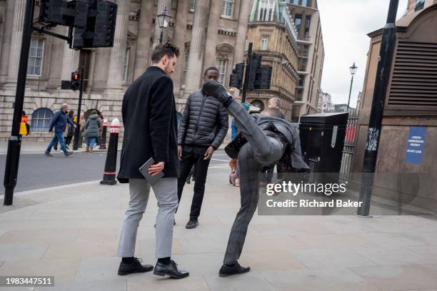 Young man practices high kicks in front of workmates in the City of London, the capital's financial district, on 6th February 2024, in London,...