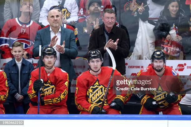 Head coach Rick Tocchet of the Vancouver Canucks and NHL Hall of Fame Player Wayne Gretzky applaud while Elias Pettersson of the Vancouver Canucks,...