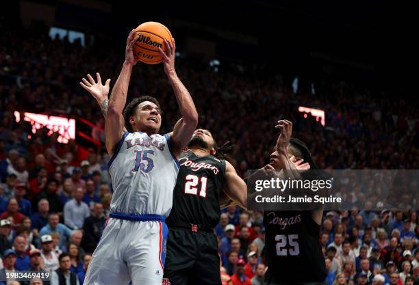 Kevin McCullar Jr. #15 of the Kansas Jayhawks shoots over Emanuel Sharp and Joseph Tugler of the Houston Cougars during the first half of the game at...