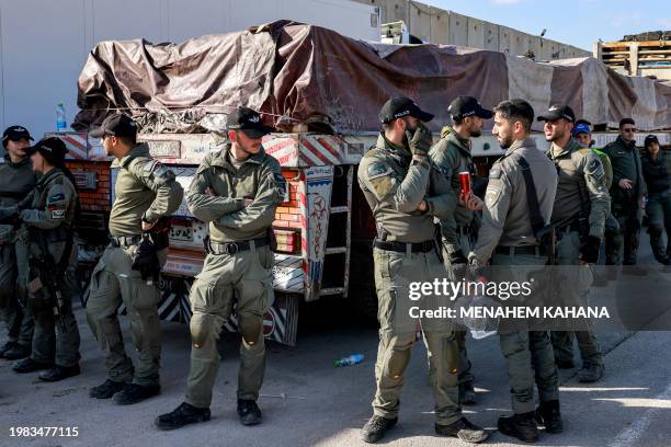 Israeli security forces stand guard by one of the Egyptian trucks bringing in humanitarian aid supplies to the Gaza Strip, on the Israeli side of the...