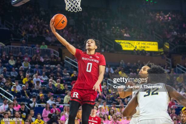 Derek Simpson of the Rutgers Scarlet Knights attempts a layup after getting past Terrance Williams II and Tarris Reed Jr. #32 of the Michigan...