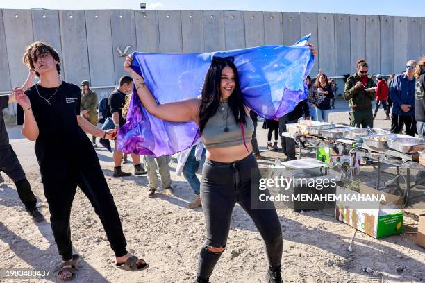 People dance as right-wing Israeli protesters gather to block the entry of humanitarian aid trucks to the Gaza Strip, on the Israeli side of the...