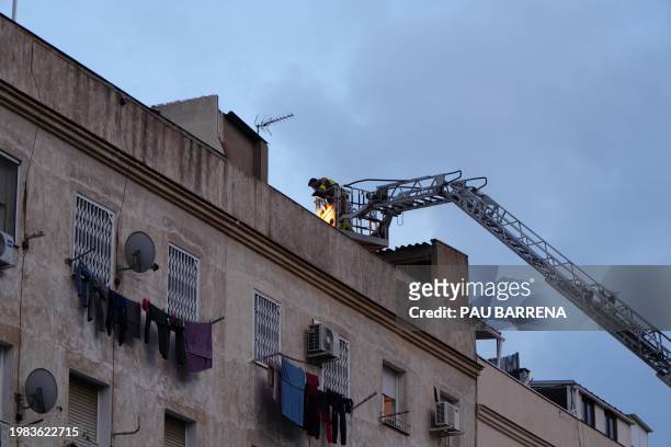Firefighters inspect a building from a ladder as emergency services are looking for potential victims after a habitation building has collapsed, in...