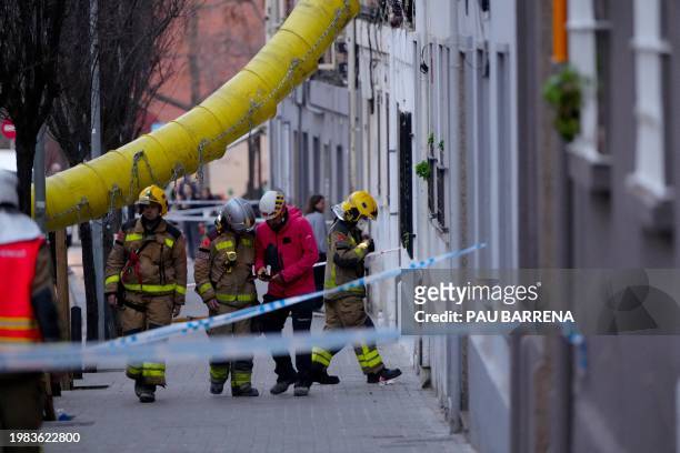Firefighters inspect a building as emergency services are looking for potential victims after a habitation building has collapsed, in Badalona on...