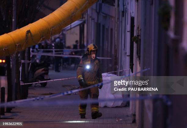 Firefighter inspects a building as emergency services are looking for potential victims after a habitation building has collapsed, in Badalona on...