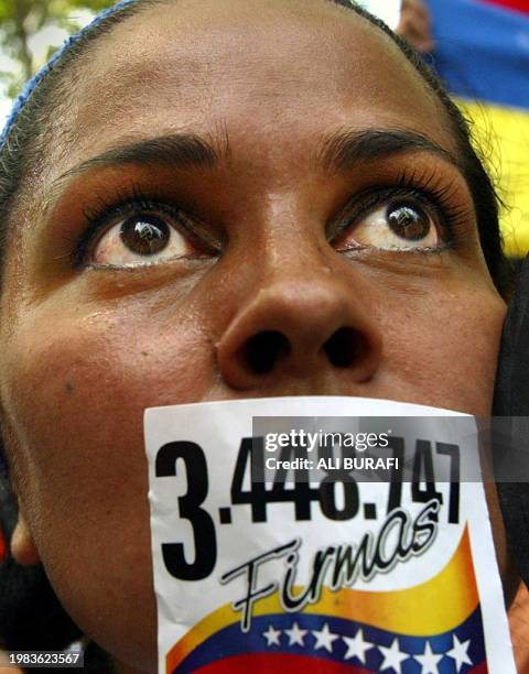 An oppositor of Venezuelan President Hugo Chavez demonstrates with a sticker in hers mouth where is written "3.448.747 signatures", 05 March 2004 at...